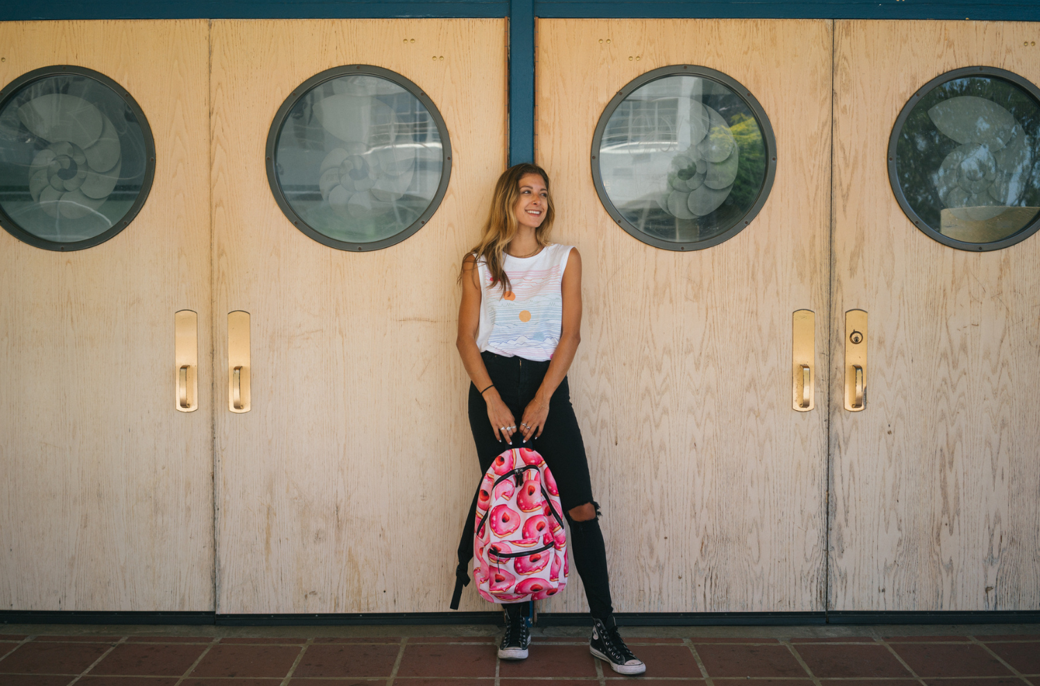 A woman holding a backpack outside