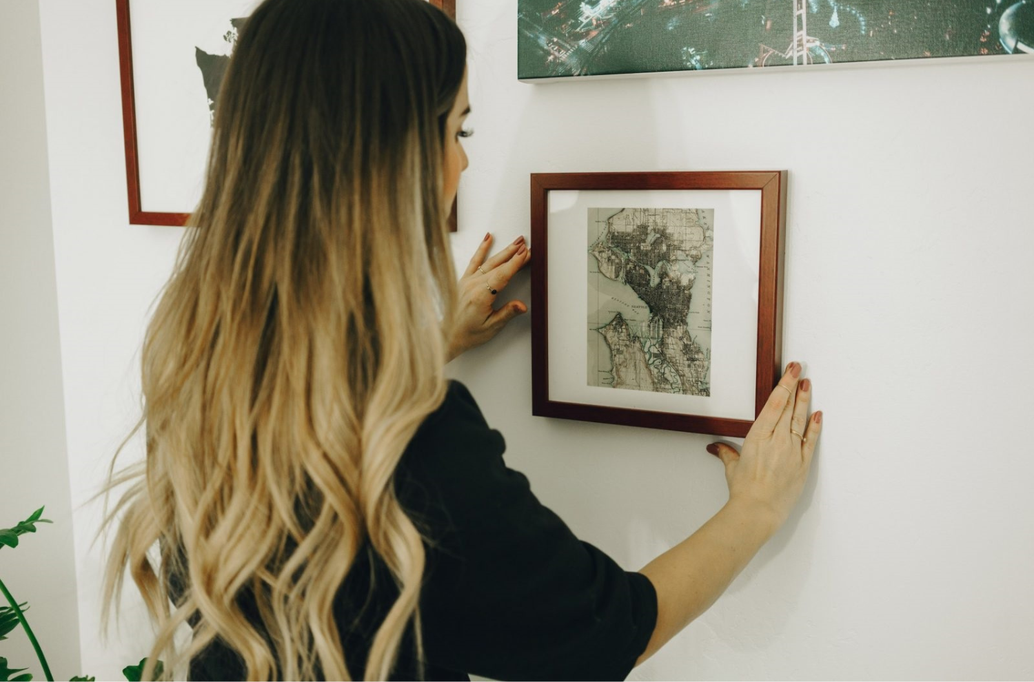 A person hanging up a photo frame