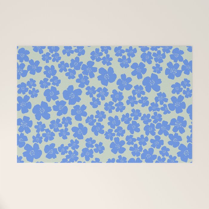 Blue flower blossom scatter on soft green Welcome Mat Gallery Image 1