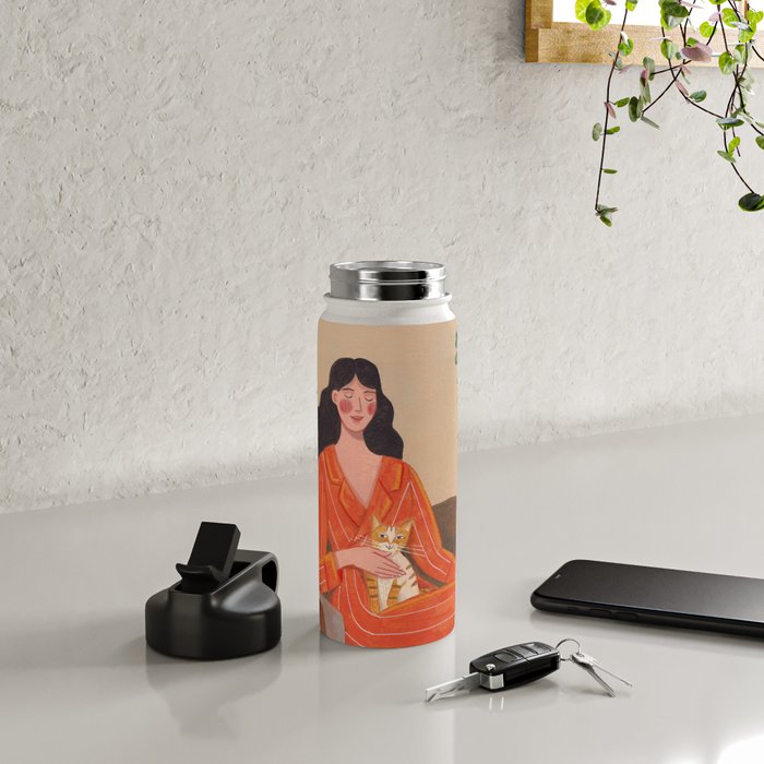 Woman with cat in living room in warm earth tones Water Bottle Gallery Image 4