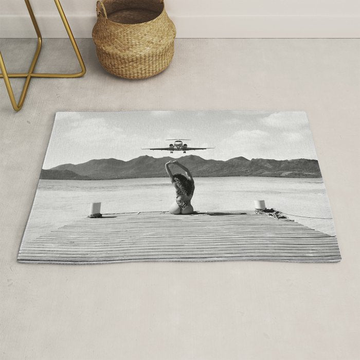 Steady as she goes girl in bikini on a dock with plane landing black and white photograph Rug Gallery Image 1