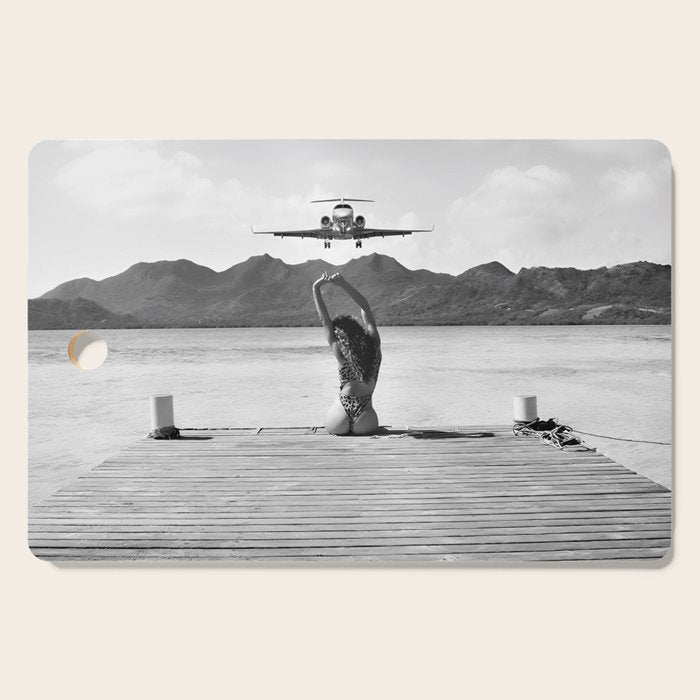 Steady as she goes girl in bikini on a dock with plane landing black and white photograph Cutting Board Gallery Image 1
