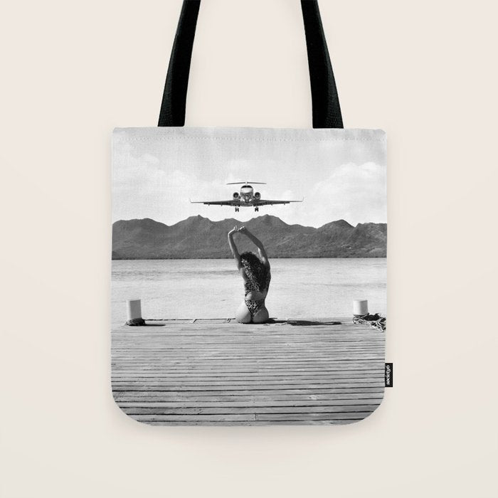 Steady as she goes girl in bikini on a dock with plane landing black and white photograph Tote Bag Gallery Image 1