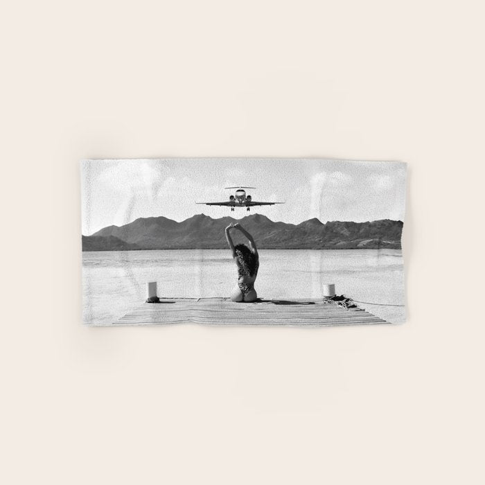 Steady as she goes girl in bikini on a dock with plane landing black and white photograph Bath Towel Gallery Image 1