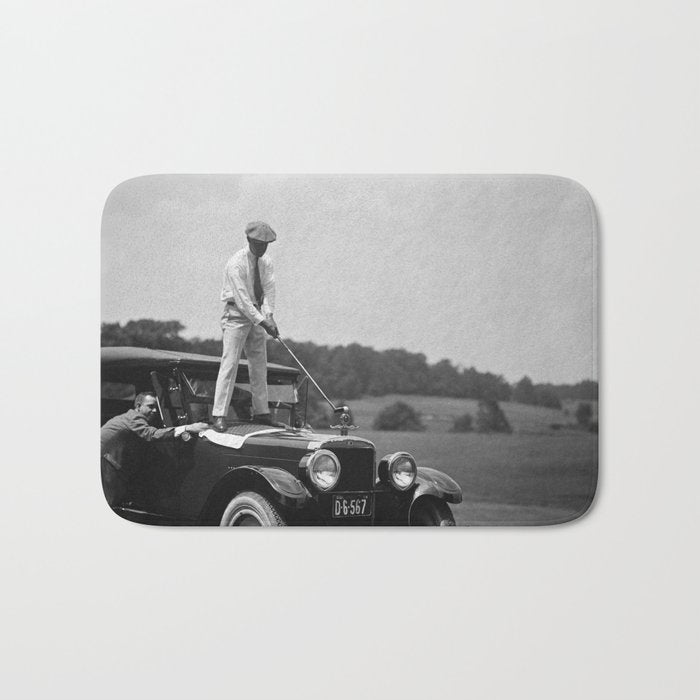 Pro golfer hitting golf ball off vintage car hood ornament on a dare par one 18th hole funny black and white golf sport photograph - photography - photographs Bath Mat Gallery Image 1