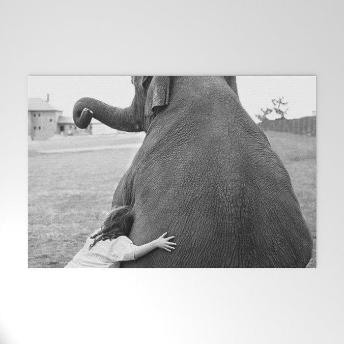 Odd Best Friends, Sweet Little Girl hugging elephant black and white photograph Welcome Mat Gallery Image 1