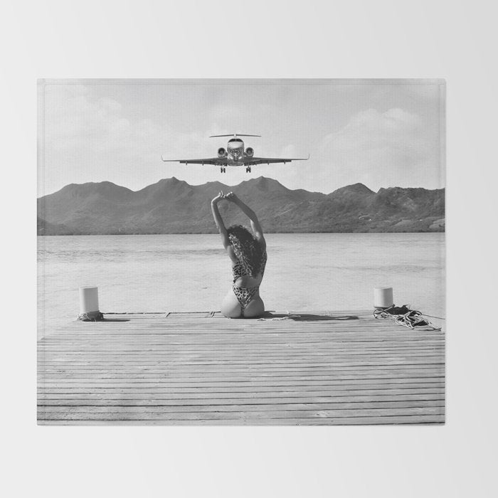 Steady as she goes girl in bikini on a dock with plane landing black and white photograph Throw Blanket Gallery Image 2