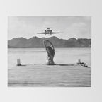 Steady as she goes girl in bikini on a dock with plane landing black and white photograph Throw Blanket Gallery Image 2