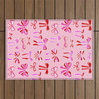 Festive Pink and Red Christmas Ribbons and Bows hand drawn Collection on Pastel Pink Outdoor Rug Gallery Image 1