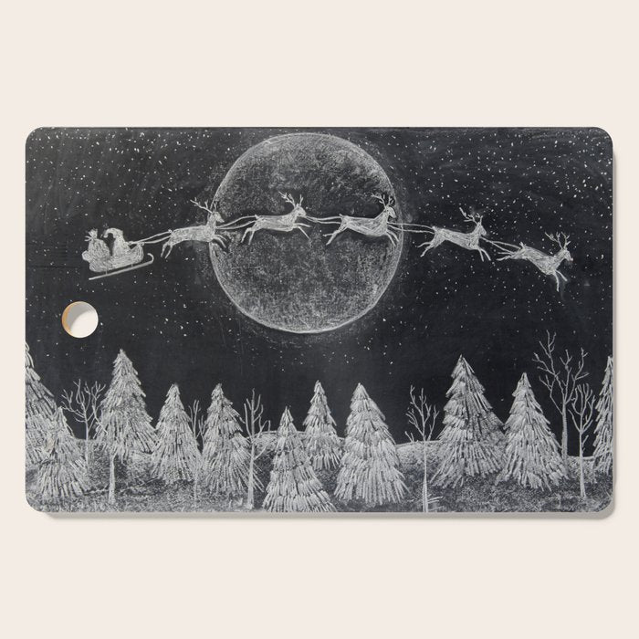 Santa flying over a winter wonderland of snow covered trees in his reindeer drawn sleigh by the light of a full moon Cutting Board Gallery Image 1