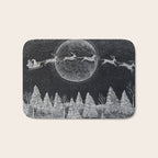 Santa flying over a winter wonderland of snow covered trees in his reindeer drawn sleigh by the light of a full moon Bath Mat Gallery Image 1