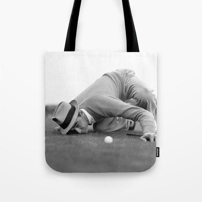 Eye to the ground on the 18th hole; golfing man eyes ball to measure distance to hole vintage black and white portrait photograph - photography - photographs poster Tote Bag Gallery Image 1