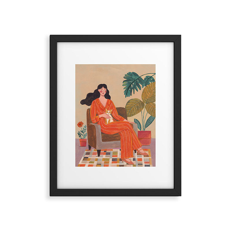 Woman with cat in living room in warm earth tones Framed Art Print