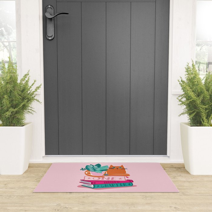 One more chapter // pastel pink background orange tabby cat striped mug with plants fuchsia pink and green books  Welcome Mat Gallery Image 3