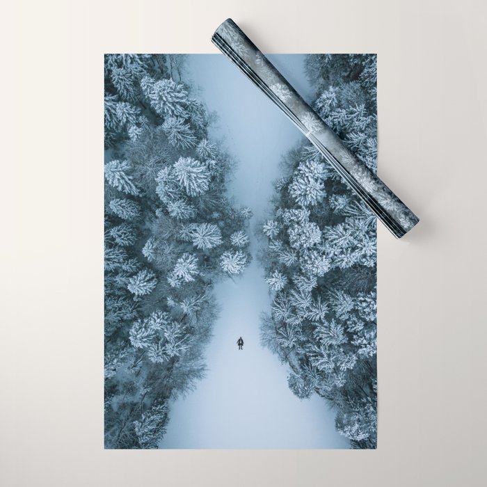 Man lying in the snow on a frozen lake in a winter forest - Landscape Photography Wrapping Paper Gallery Image 1