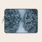 Man lying in the snow on a frozen lake in a winter forest - Landscape Photography Laptop Sleeve Gallery Image 1