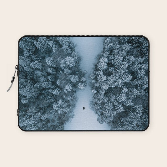 Man lying in the snow on a frozen lake in a winter forest - Landscape Photography Laptop Sleeve Gallery Image 1