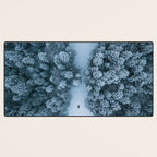 Man lying in the snow on a frozen lake in a winter forest - Landscape Photography Desk Mat Gallery Image 3