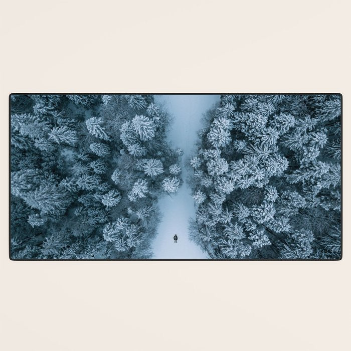 Man lying in the snow on a frozen lake in a winter forest - Landscape Photography Desk Mat Gallery Image 3