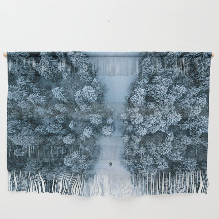 Man lying in the snow on a frozen lake in a winter forest - Landscape Photography Wall Hanging Gallery Image 1