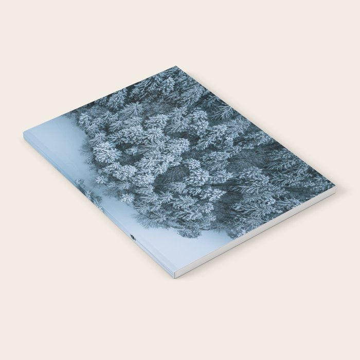 Man lying in the snow on a frozen lake in a winter forest - Landscape Photography Notebook Gallery Image 1