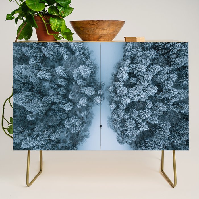 Man lying in the snow on a frozen lake in a winter forest - Landscape Photography Credenza Gallery Image 1