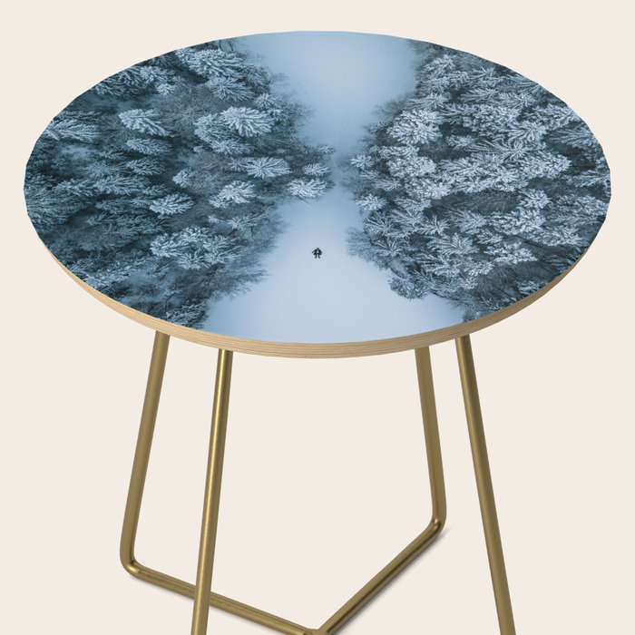 Man lying in the snow on a frozen lake in a winter forest - Landscape Photography Side Table Gallery Image 2
