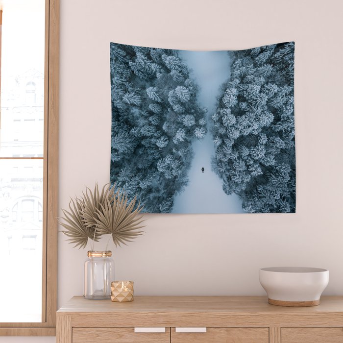 Man lying in the snow on a frozen lake in a winter forest - Landscape Photography Wall Tapestry Gallery Image 2