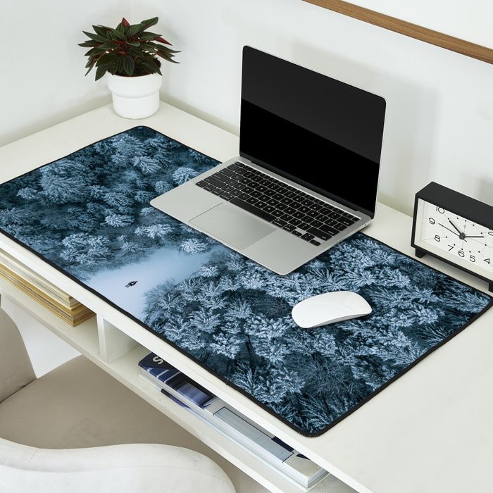 Man lying in the snow on a frozen lake in a winter forest - Landscape Photography Desk Mat Gallery Image 2