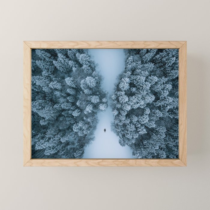 Man lying in the snow on a frozen lake in a winter forest - Landscape Photography Mini Art Print Gallery Image 1