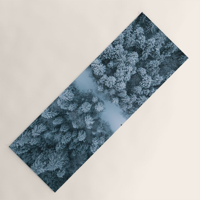 Man lying in the snow on a frozen lake in a winter forest - Landscape Photography Yoga Mat Gallery Image 1