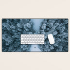 Man lying in the snow on a frozen lake in a winter forest - Landscape Photography Desk Mat Gallery Image 1