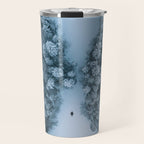 Man lying in the snow on a frozen lake in a winter forest - Landscape Photography Travel Mug Gallery Image 1