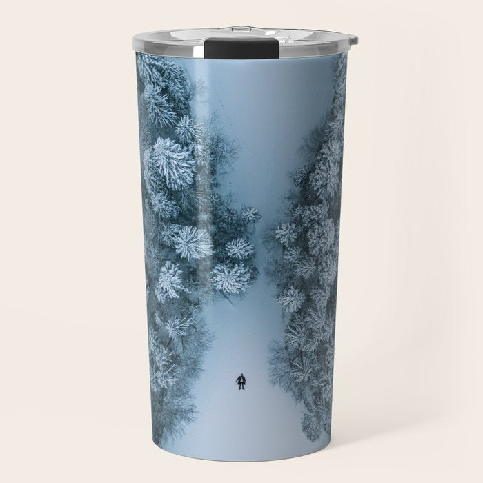 Man lying in the snow on a frozen lake in a winter forest - Landscape Photography Travel Mug Gallery Image 1