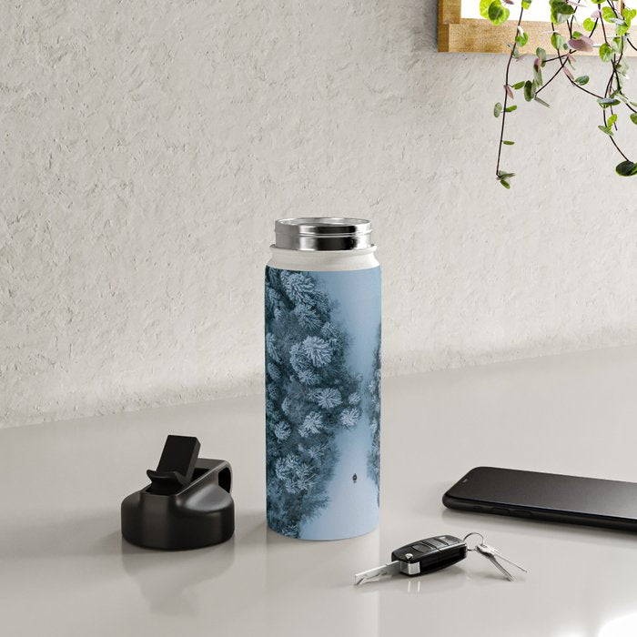 Man lying in the snow on a frozen lake in a winter forest - Landscape Photography Water Bottle Gallery Image 5