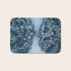 Man lying in the snow on a frozen lake in a winter forest - Landscape Photography Bath Mat Gallery Image 1